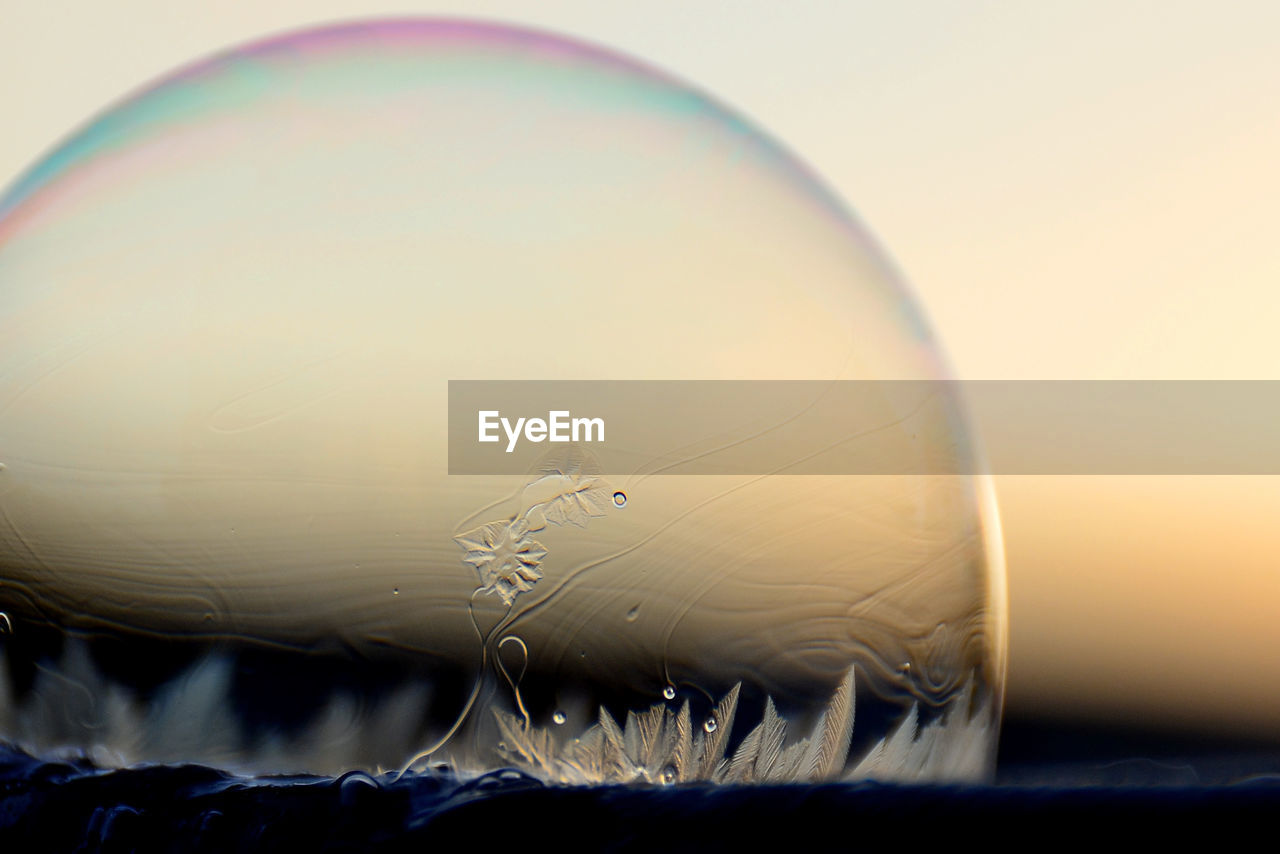 Close-up of bubble against sky during sunset