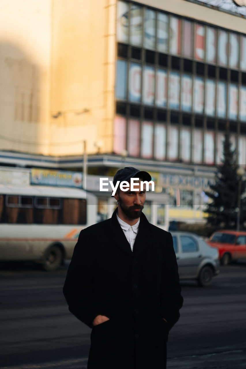 Portrait of young man standing in city