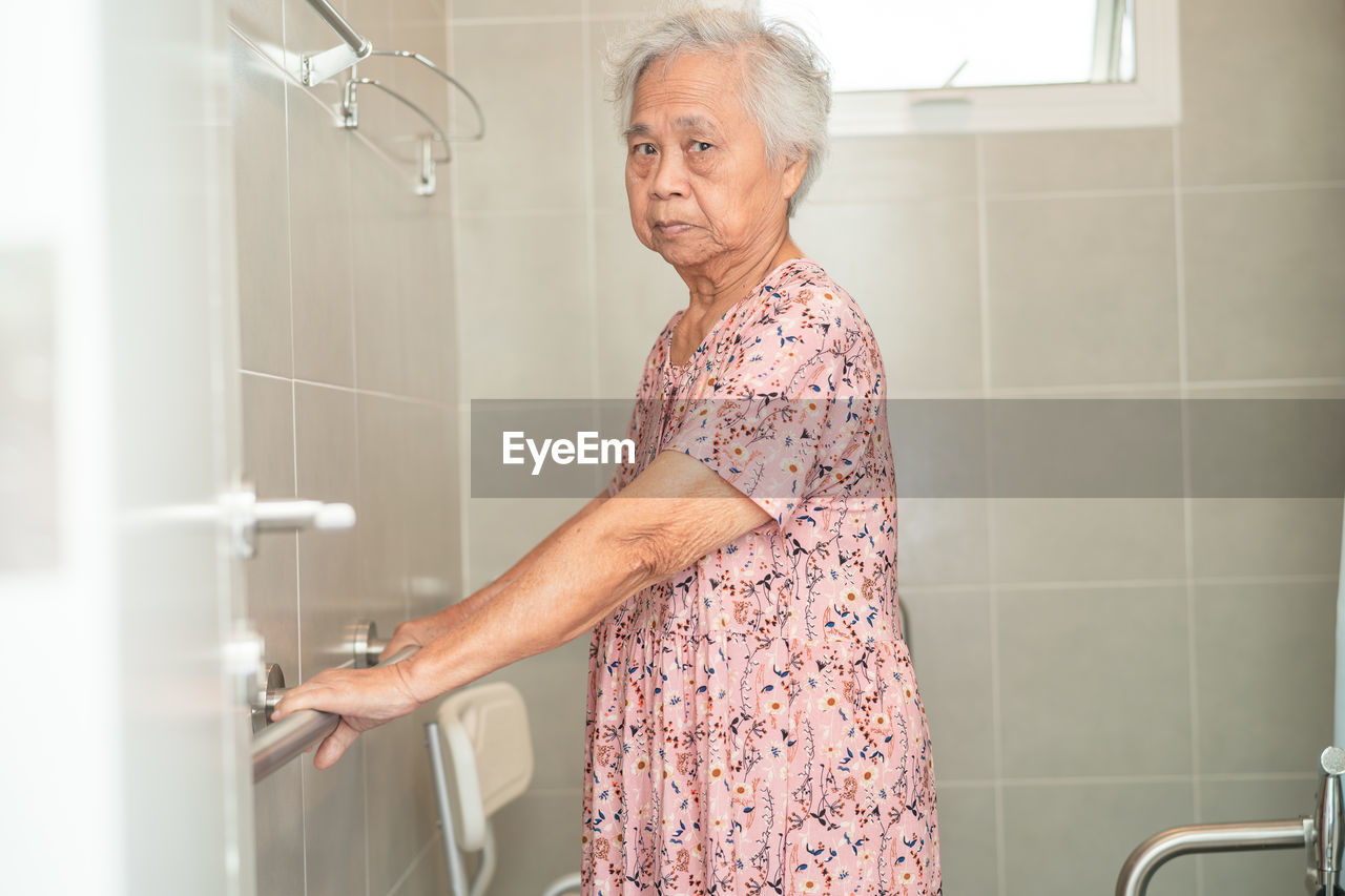 Asian elderly woman patient use toilet bathroom handle security 