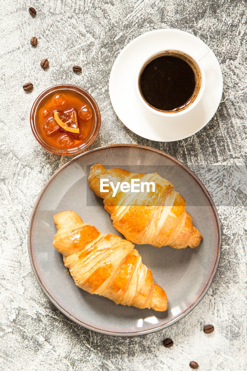 Breakfast with croissants. fresh crispy croissants and coffee on a light background, top view/