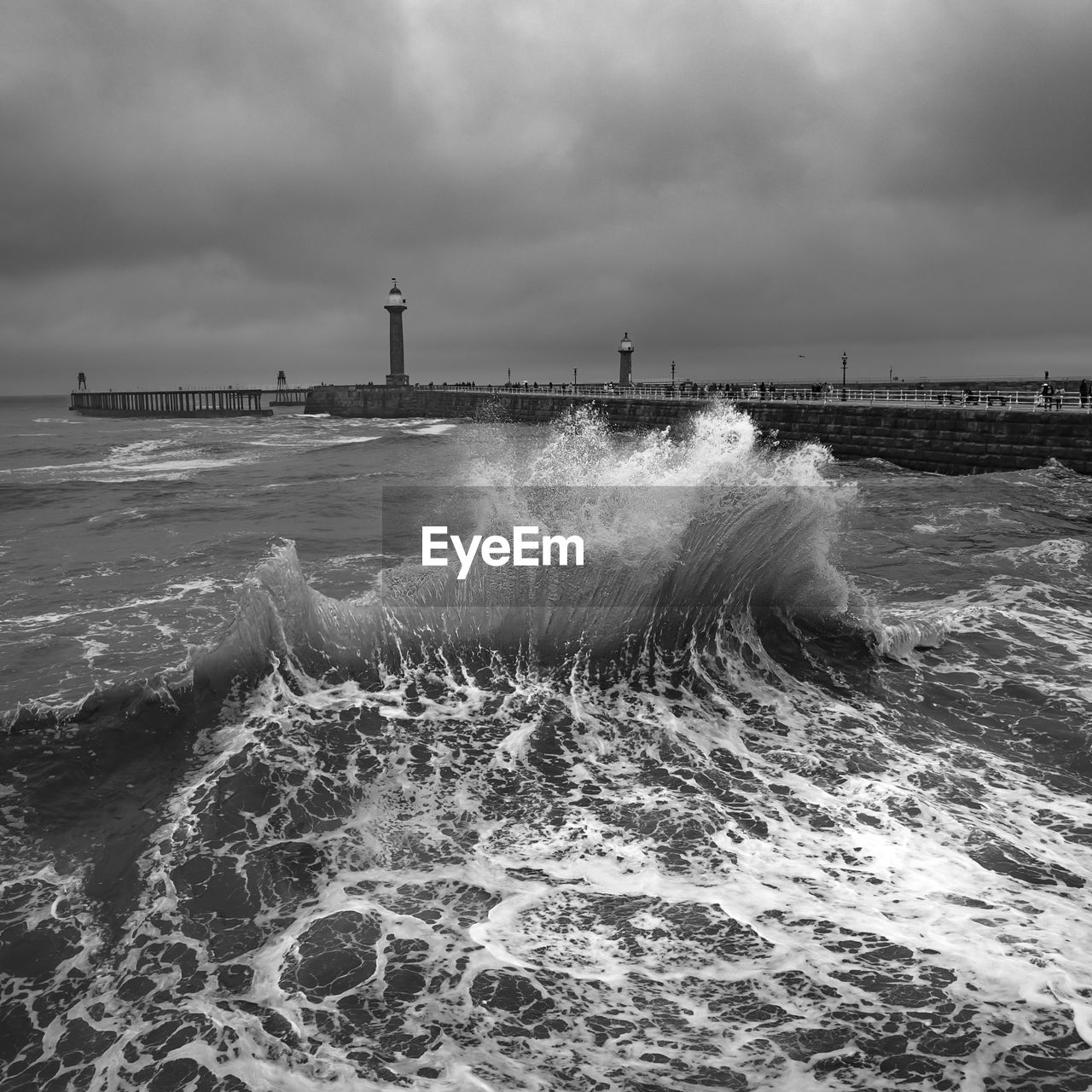 water, sea, wave, sky, motion, wind wave, ocean, beach, shore, black and white, cloud, land, coast, architecture, nature, built structure, monochrome photography, power in nature, monochrome, beauty in nature, horizon, building exterior, environment, water sports, lighthouse, breakwater, scenics - nature, surfing, sports, storm, outdoors, tower, travel destinations, wind, building, horizon over water, day, travel, pier, landscape, seascape