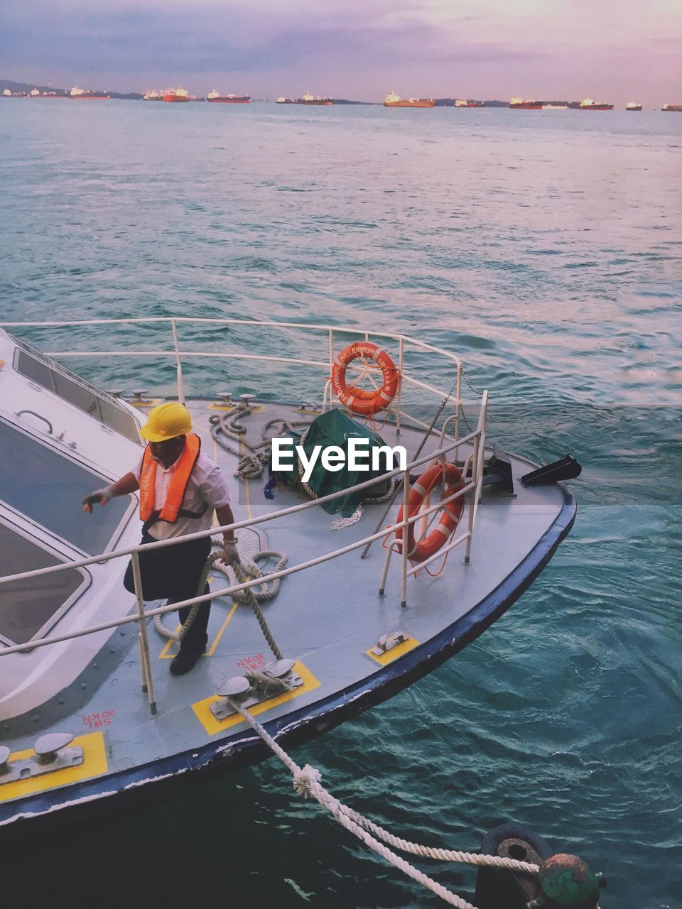 MAN MOORED ON SEA AGAINST SKY