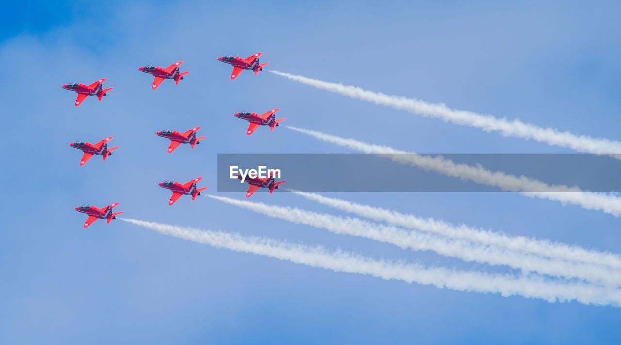 LOW ANGLE VIEW OF AIRSHOW AGAINST BLUE SKY