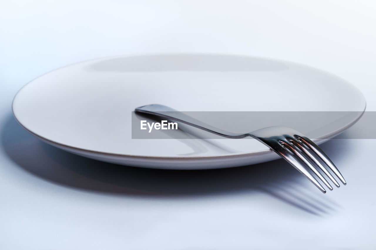 High angle view of fork in plate on table