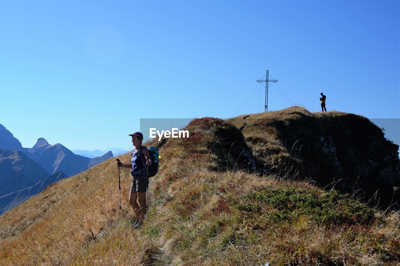 Woman standing on mountain against clear sky