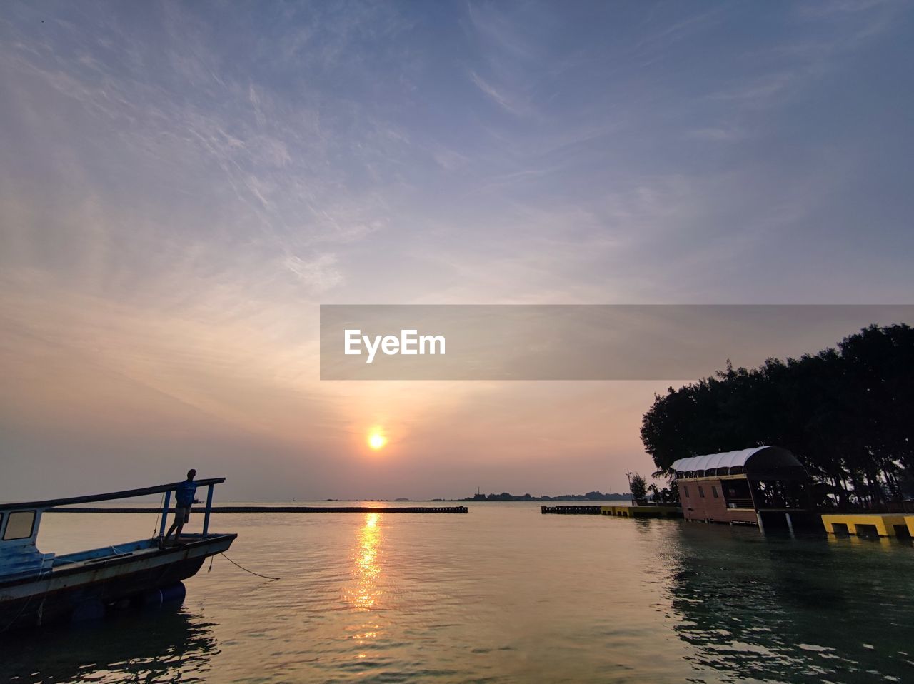 water, sky, sunset, nature, sea, beauty in nature, reflection, cloud, scenics - nature, transportation, tranquility, nautical vessel, dusk, architecture, sun, tranquil scene, evening, horizon, sunlight, vehicle, mode of transportation, travel destinations, no people, idyllic, pier, outdoors, built structure, travel, boat, tree, silhouette, land, shore, environment, landscape, beach, ship, blue, ocean, holiday, building exterior, twilight, tourism, vacation, bay