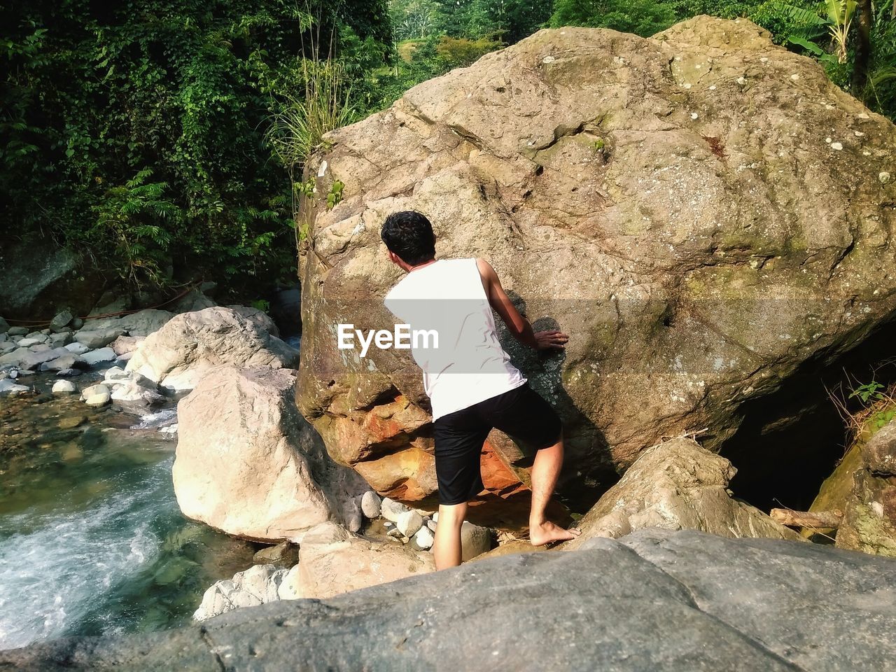 Rear view of man standing on cliff at beach