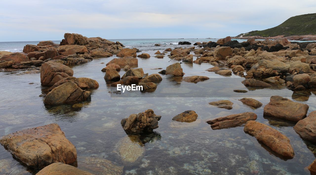 Rocks in sea against sky