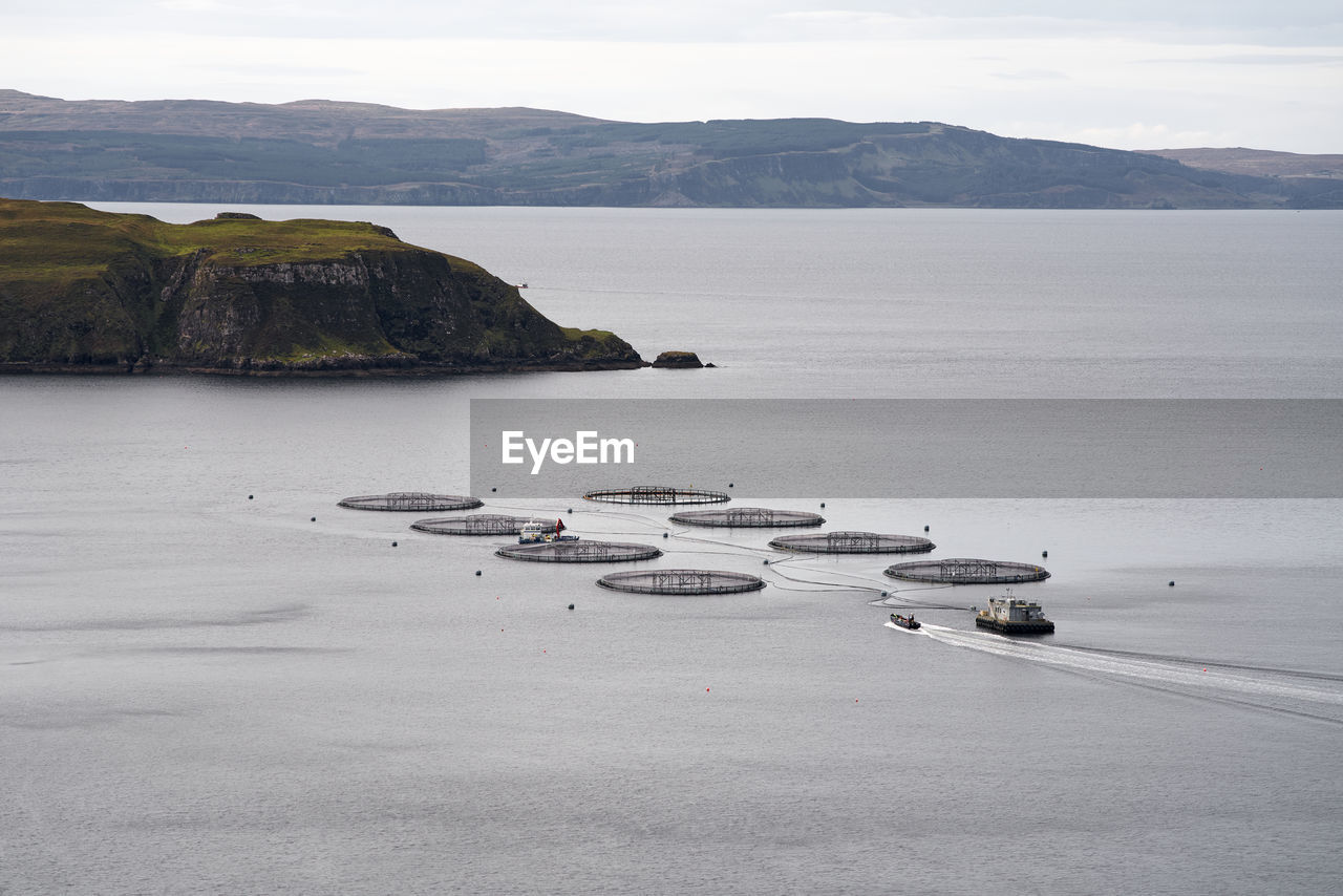 Aquaculture fish farm with approaching boat  in scotland