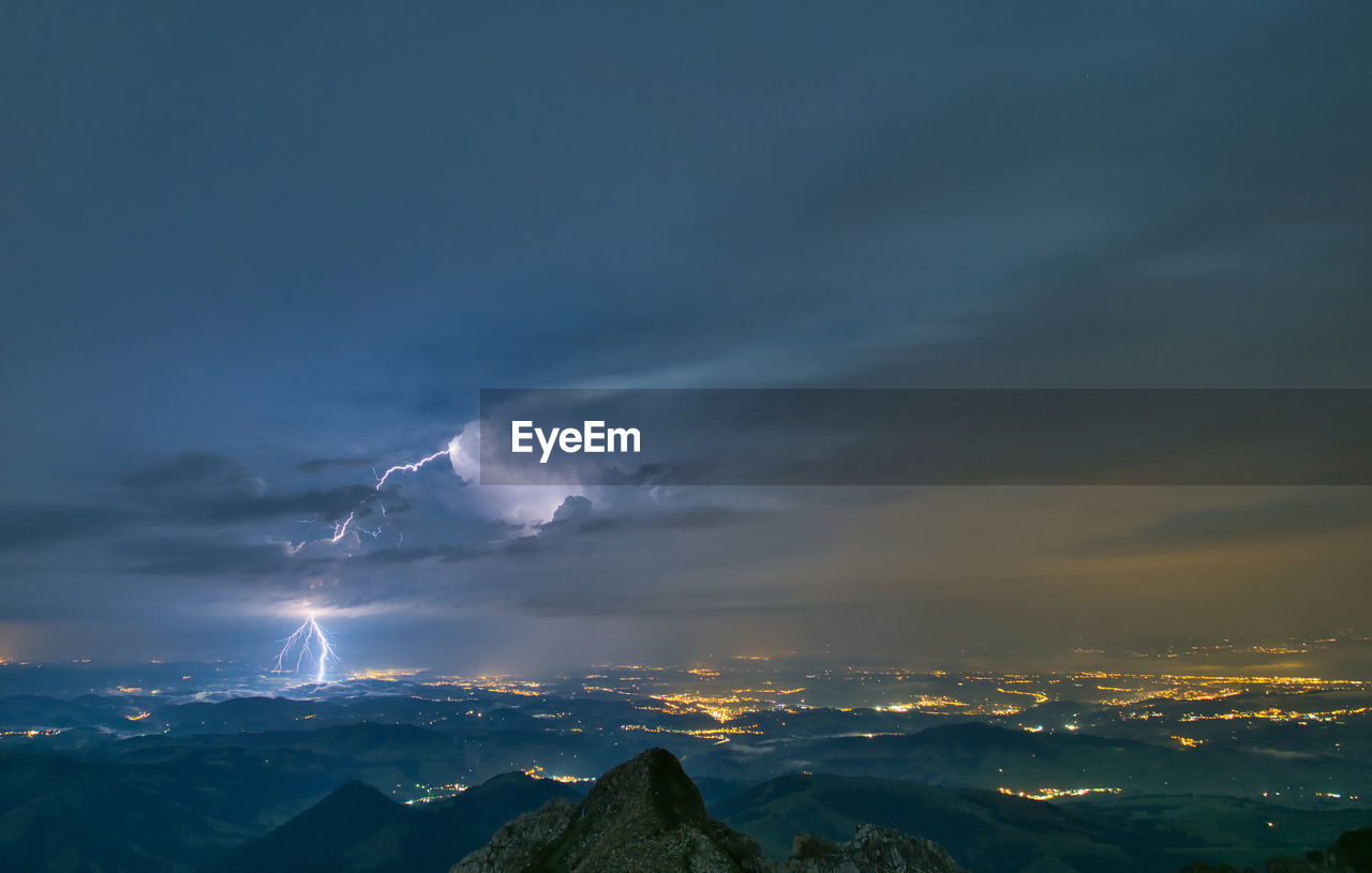 Scenic view of mountains against night sky during thunderstorm 
