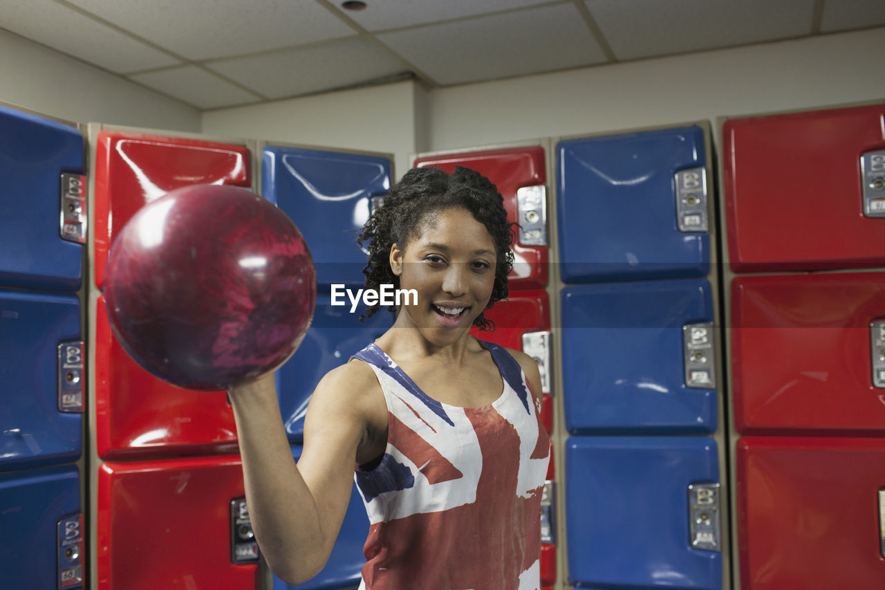 A young women holding a bowling ball.