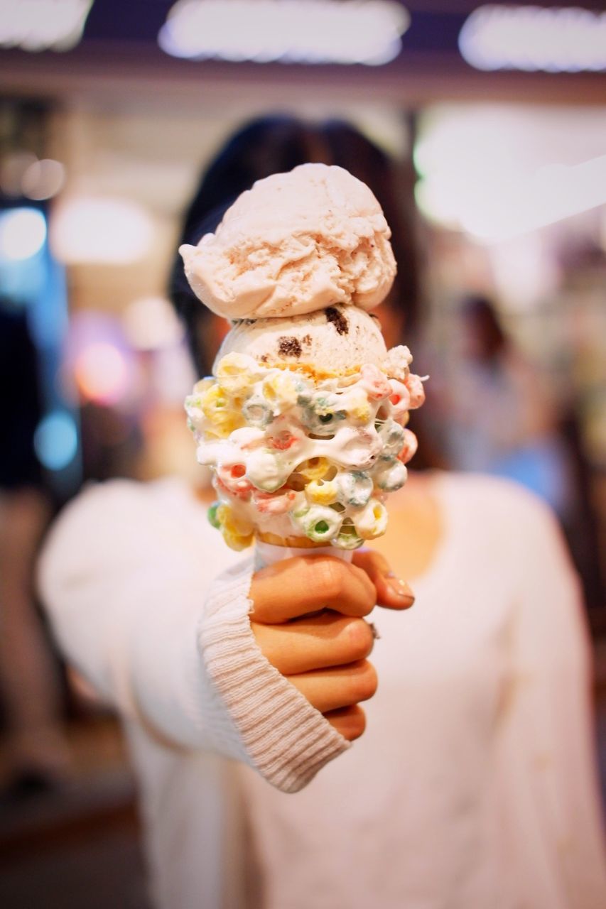 Woman holding ice cream while standing outdoors