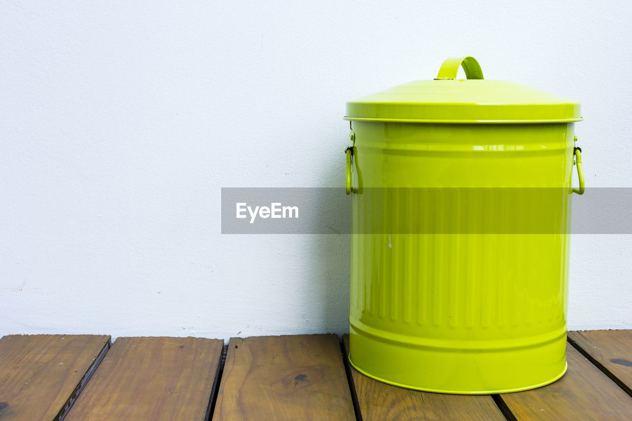 yellow, green, waste container, wall - building feature, no people, wood, indoors, container, garbage bin, flooring, recycling, environment, copy space, environmental conservation