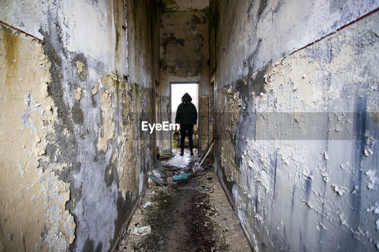 REAR VIEW OF MAN ON OLD WALL