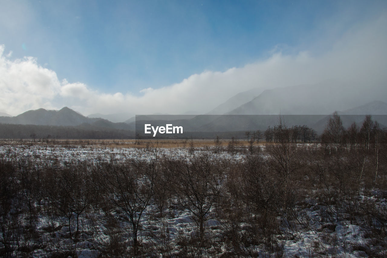 Scenic view of snow covered land against sky