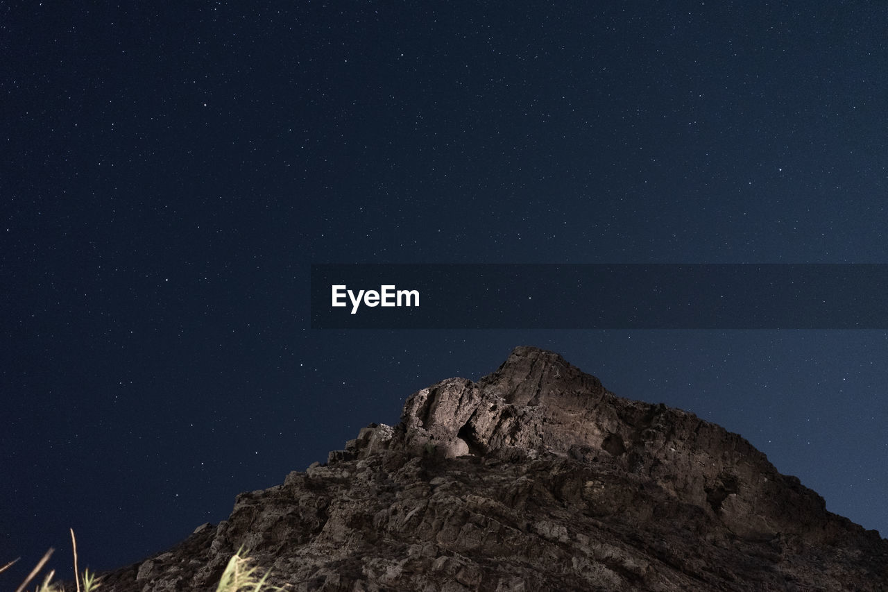 Low angle view of mountain against sky at night