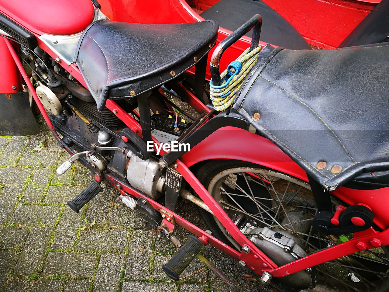 HIGH ANGLE VIEW OF RED MOTORCYCLE ON ROAD