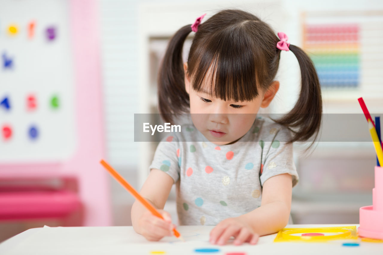 Young girl drawing different shape for home schooling 