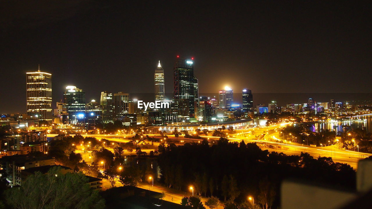 ILLUMINATED MODERN BUILDINGS IN CITY AT NIGHT