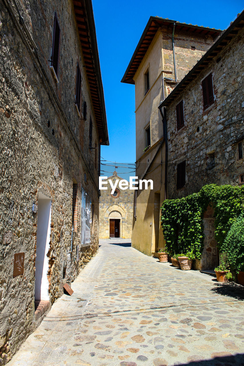 NARROW ALLEY AMIDST RESIDENTIAL BUILDINGS