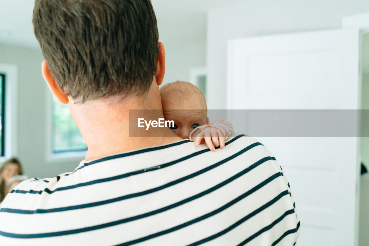Cropped portrait of a dad holding his baby over his shoulder
