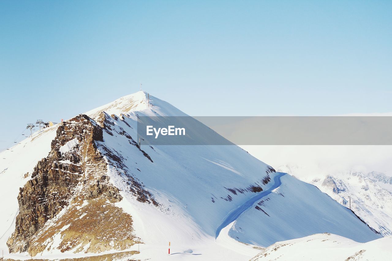 Scenic view of snowcapped mountains against clear blue sky