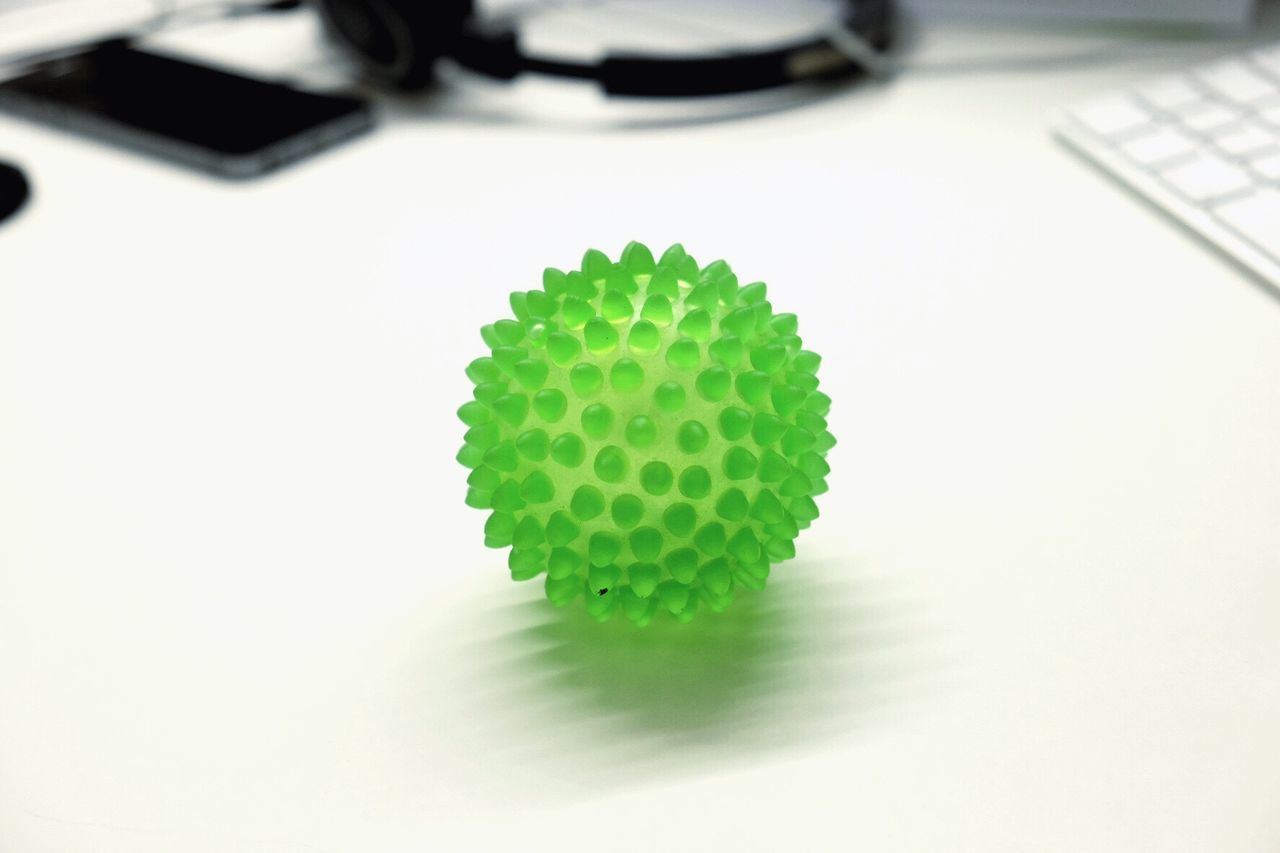 Close-up of green spiked rubber ball on table