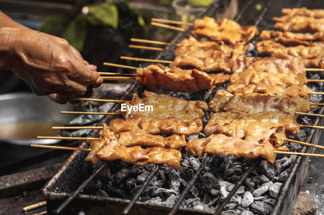 CLOSE-UP OF MEAT COOKING ON BARBECUE