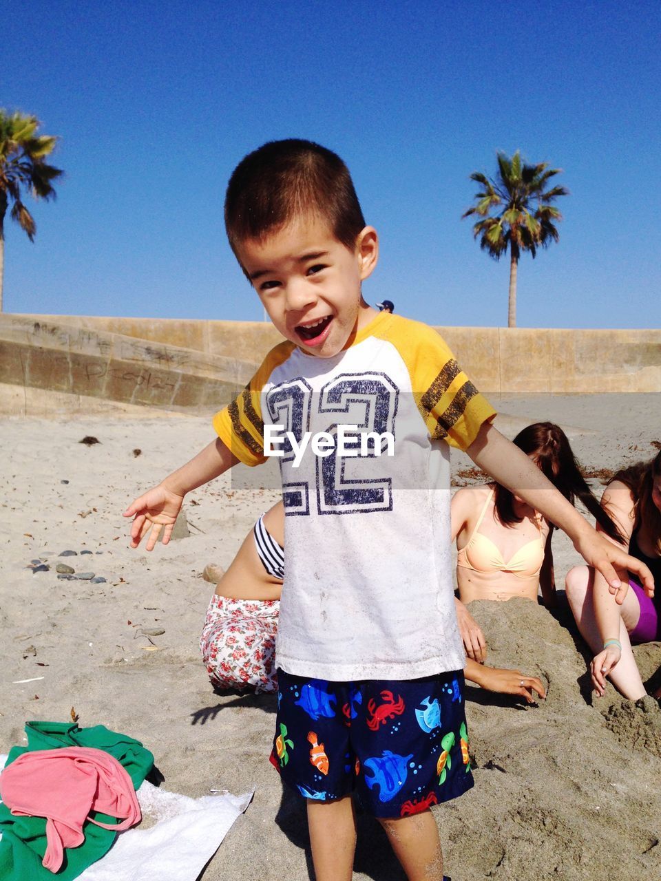 Portrait boy enjoying at beach against clear blue sky