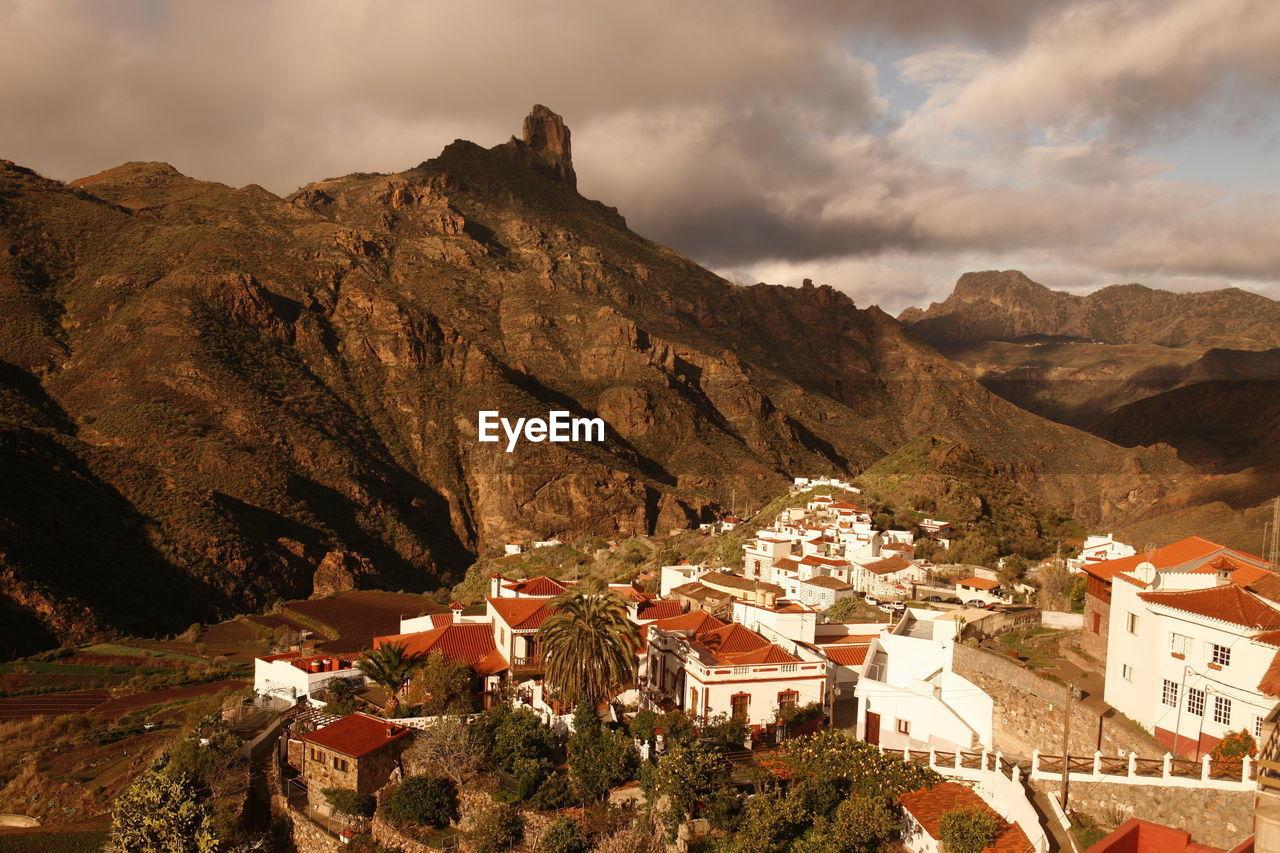 Scenic view of valley and mountains against cloudy sky