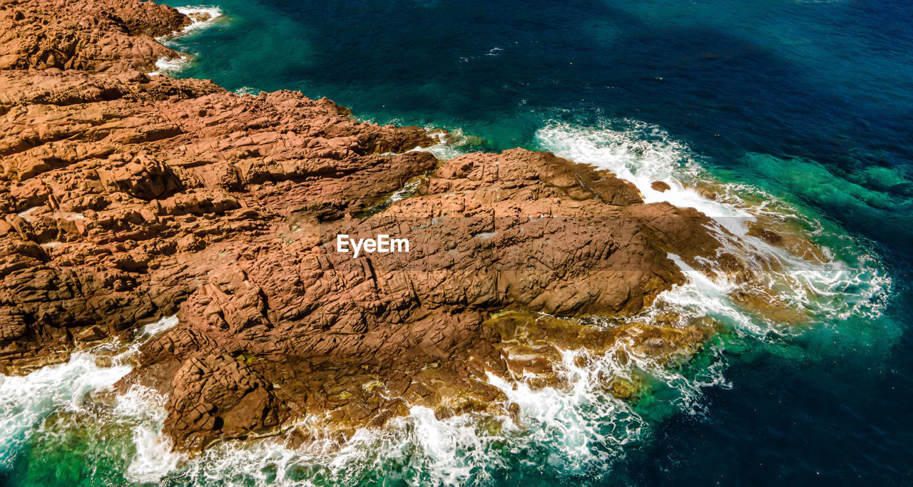 HIGH ANGLE VIEW OF ROCKS ON SHORE