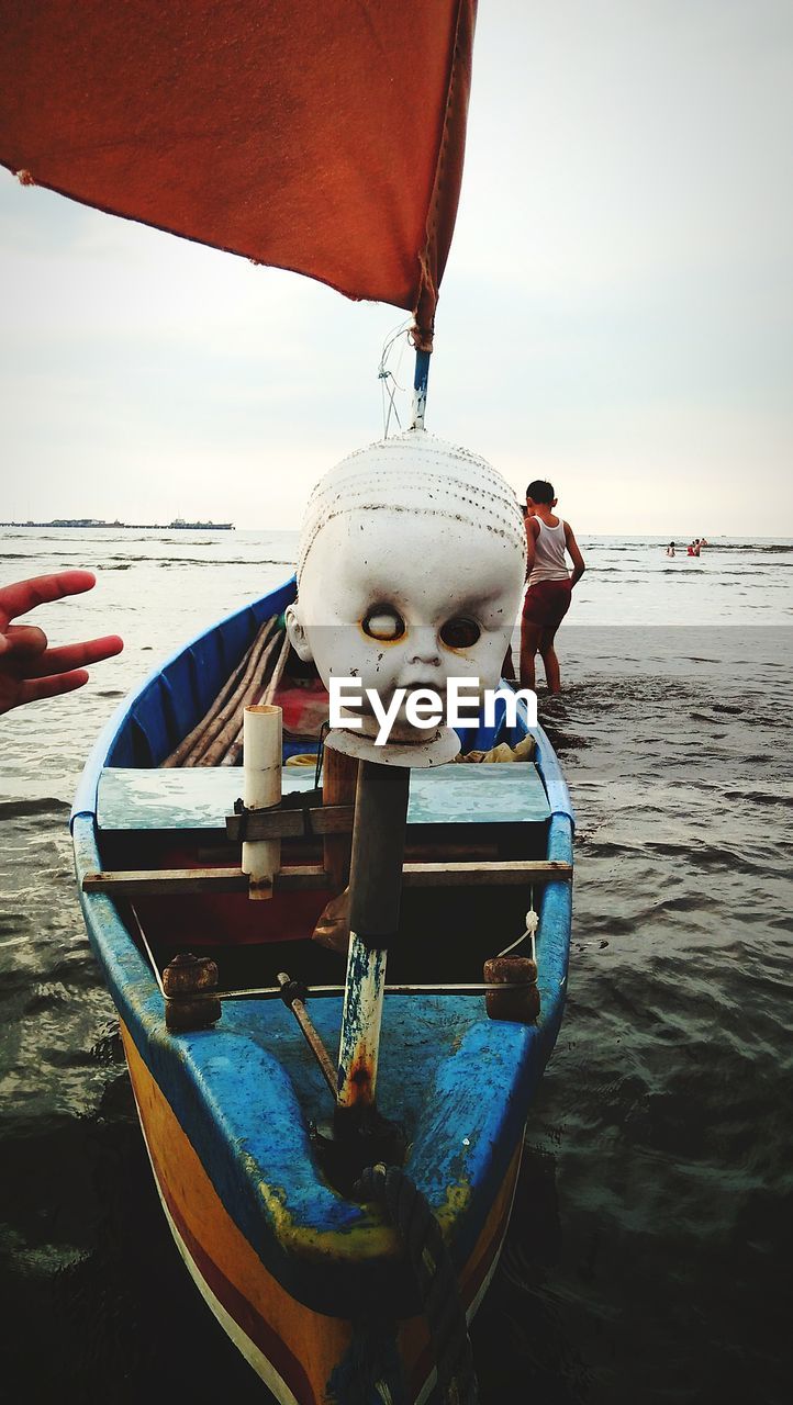 MEN IN BOAT AGAINST SKY