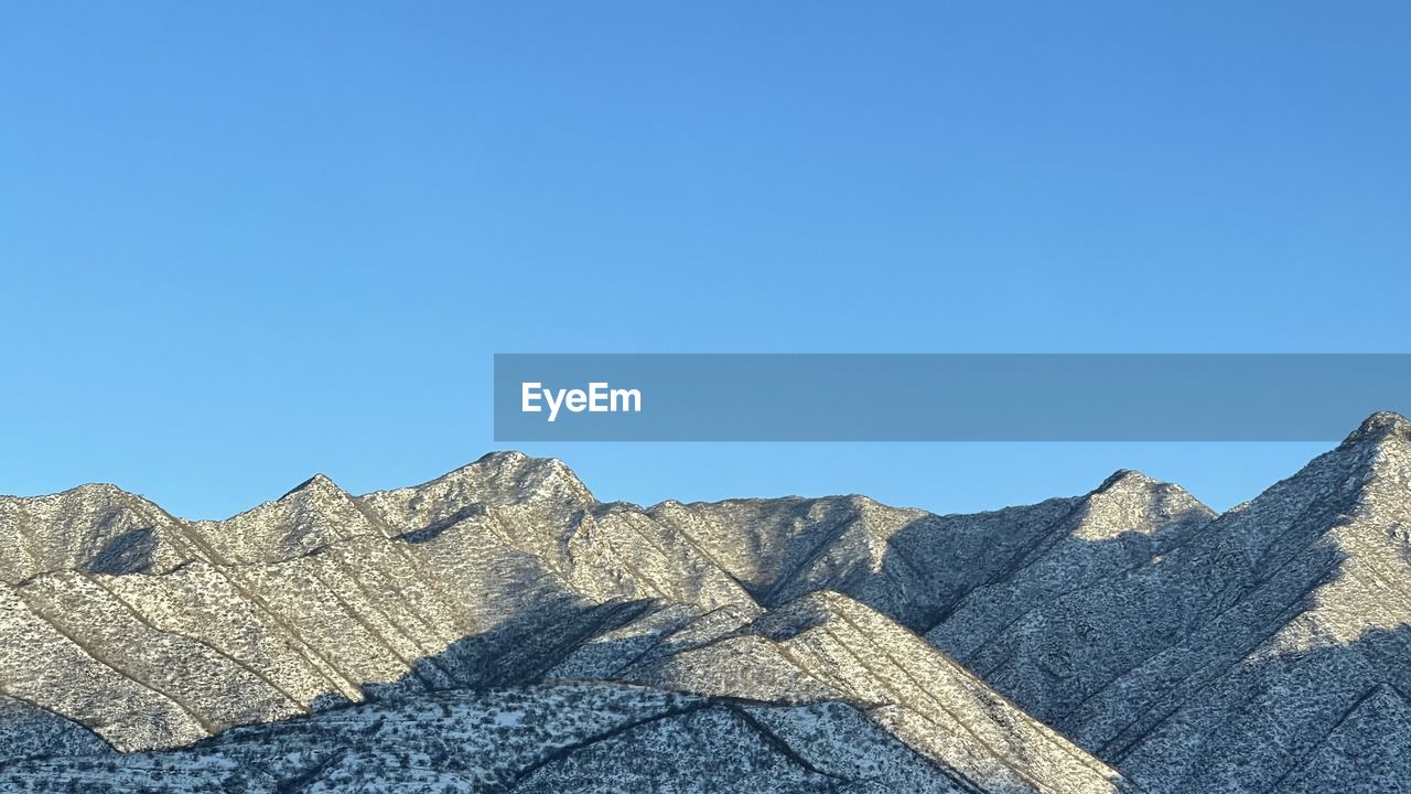 LOW ANGLE VIEW OF MOUNTAIN AGAINST BLUE SKY