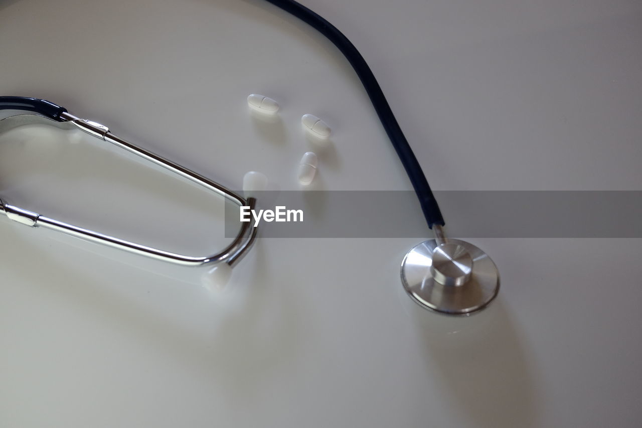 High angle view of stethoscope and medicines on gray background