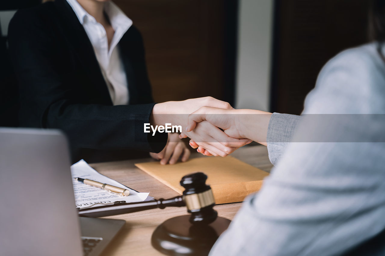 business, adult, businessman, communication, men, office, two people, meeting, corporate business, table, cooperation, working, business finance and industry, businesswoman, agreement, indoors, businesswear, technology, teamwork, women, sitting, formal wear, occupation, partnership - teamwork, business meeting, wireless technology, conversation, furniture, formal businesswear, finance, person, computer, professional occupation, selective focus, coworker, handshake, desk, female, planning, document, hand, white-collar worker, togetherness, young adult, clothing, discussion, laptop, contract, using laptop, place of work, customer