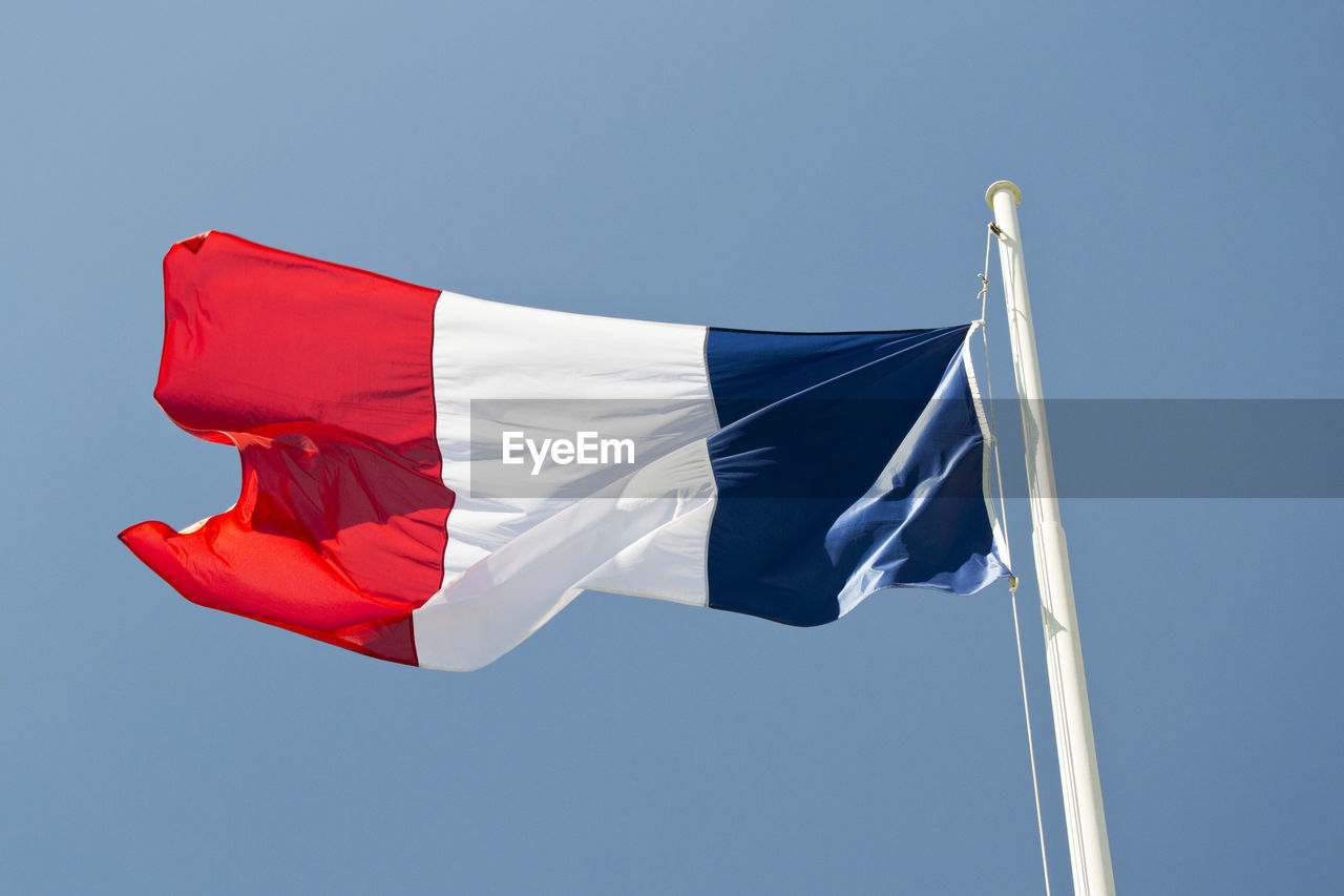 Low angle view of french flag against clear blue sky