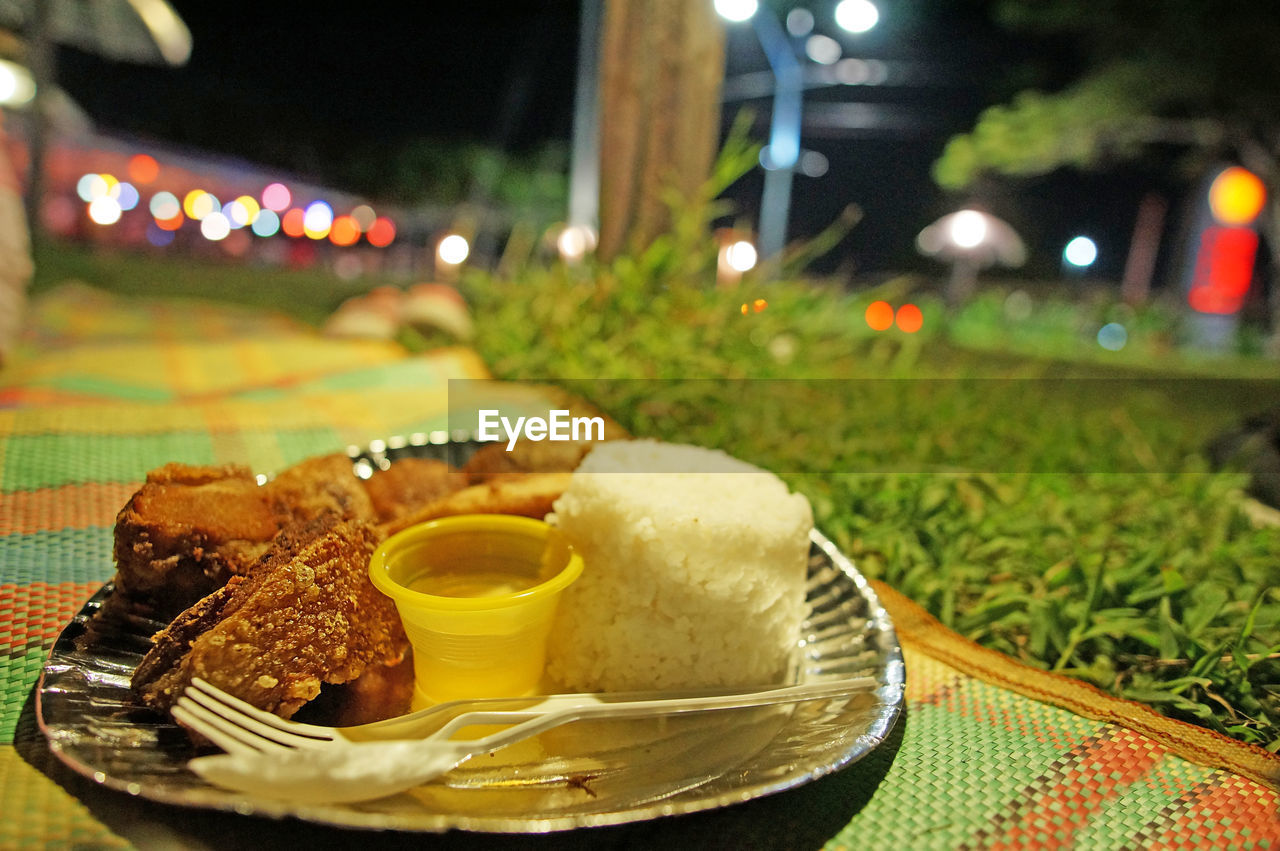 Close-up of meal served on mat at night