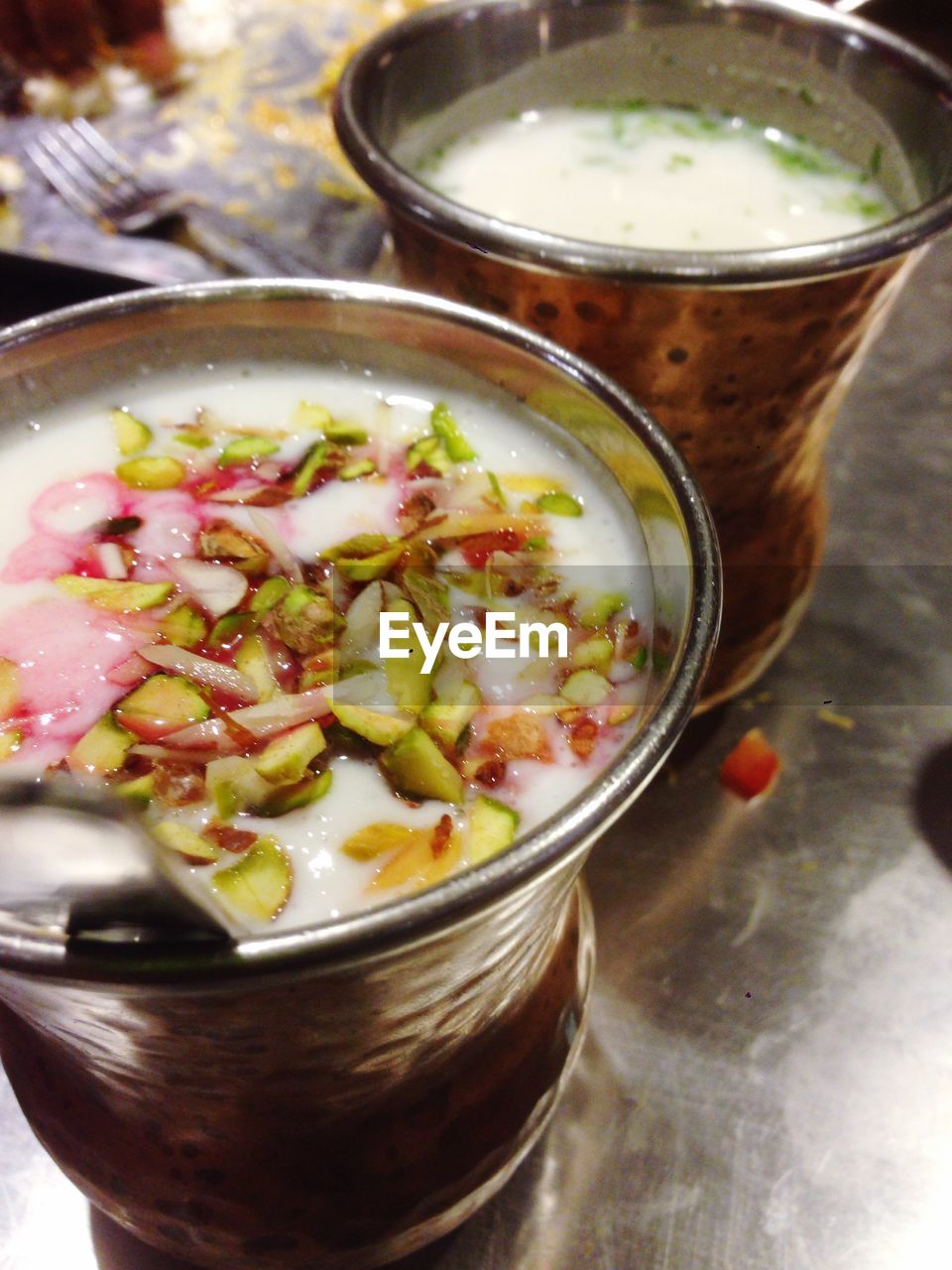 High angle view of lassi and chaas in metal glasses on table