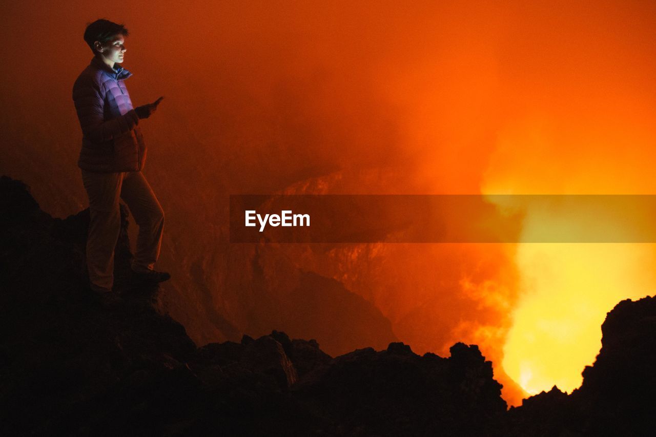 Full length of woman looking at volcanic eruption