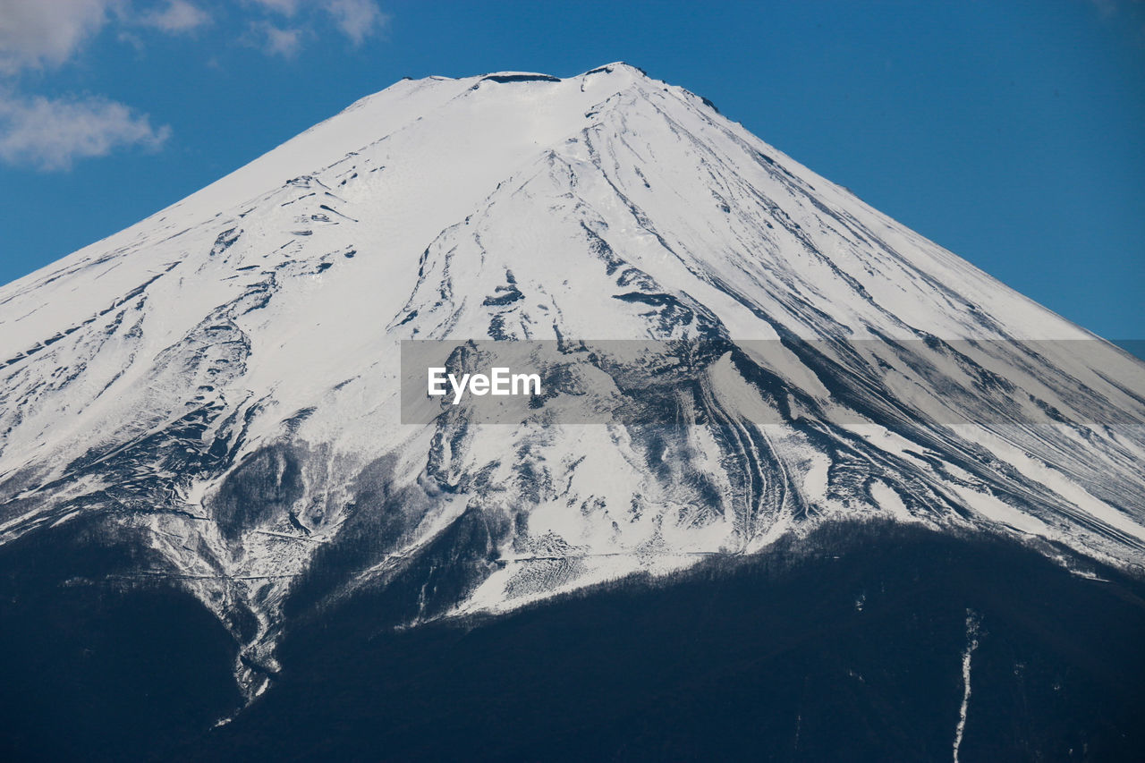 Scenic view of snowcapped mountains against blue sky