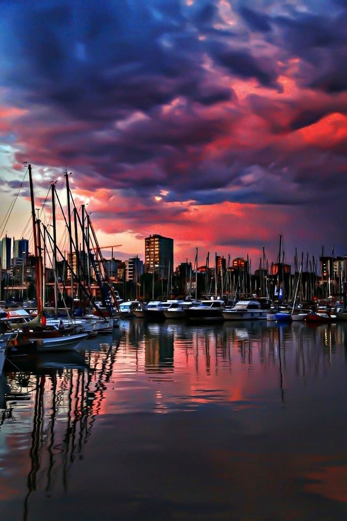 BOATS IN HARBOR WITH CITY IN BACKGROUND