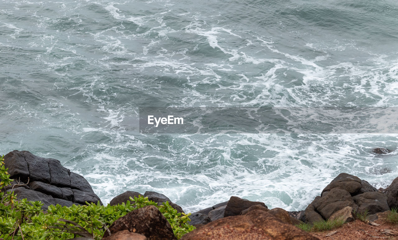 HIGH ANGLE VIEW OF ROCKS ON SHORE