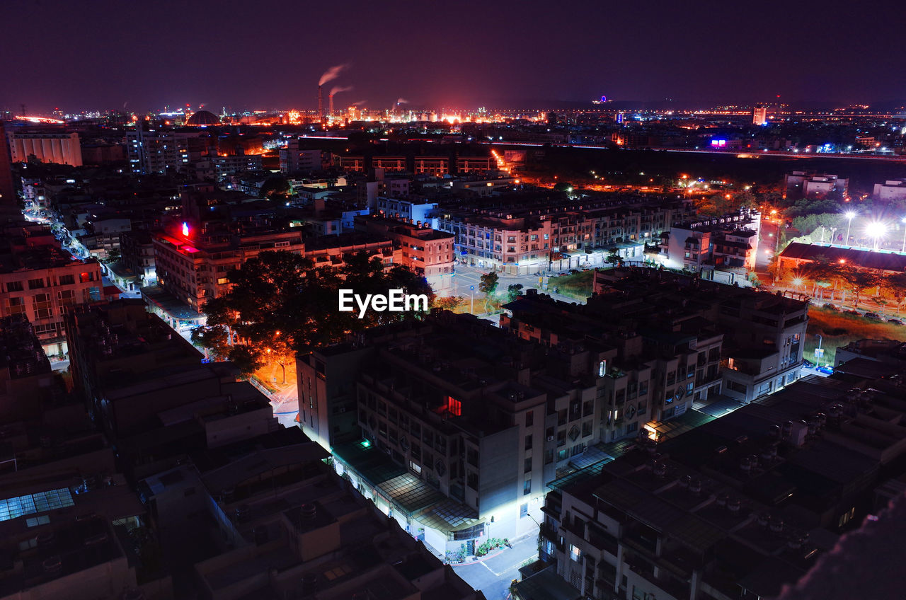 Illuminated cityscape against sky at night