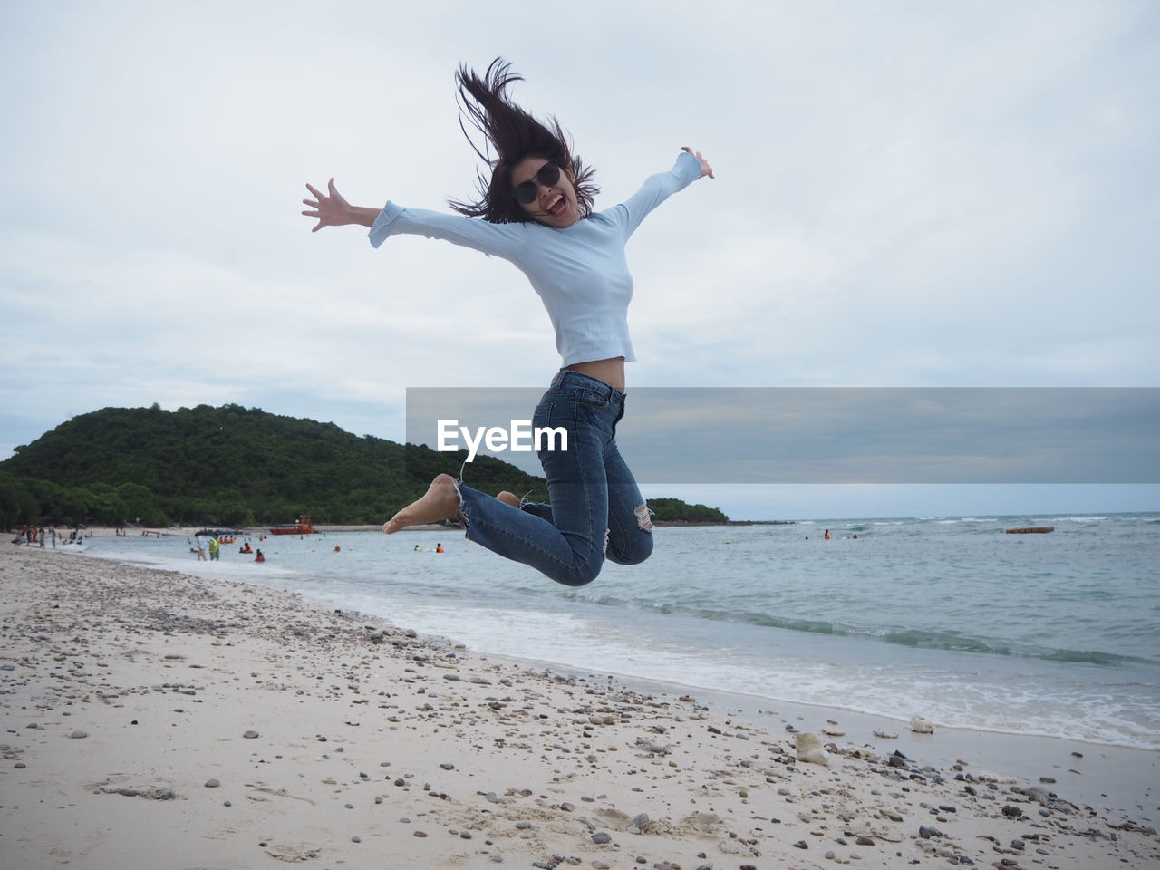 Full length of happy woman jumping at beach