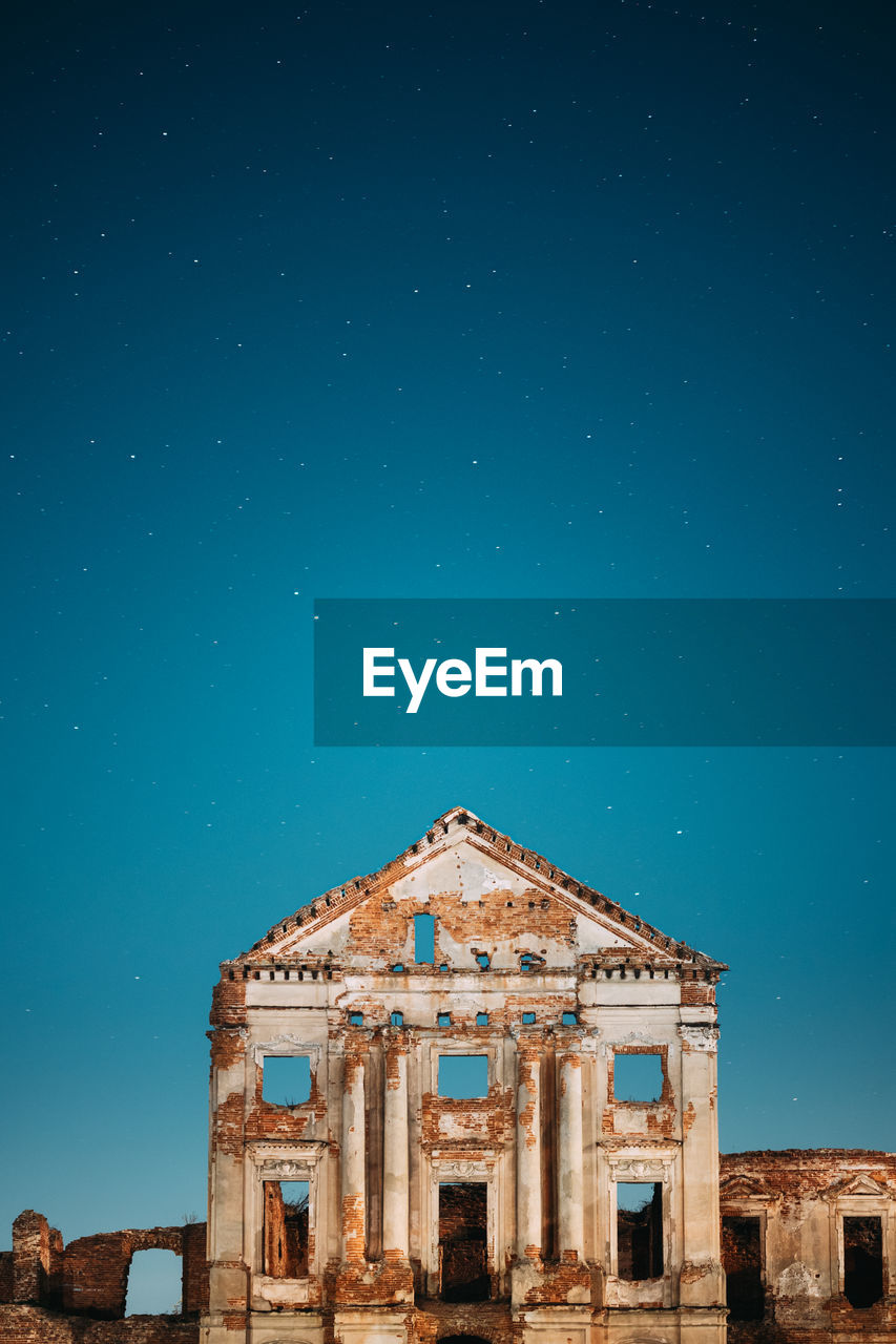 LOW ANGLE VIEW OF HISTORIC BUILDING AGAINST BLUE SKY