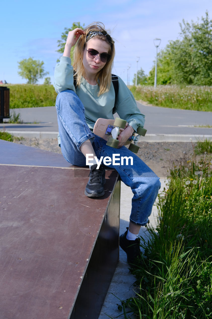 A young couple of 16-20 years old sits on a ramp in a skate park