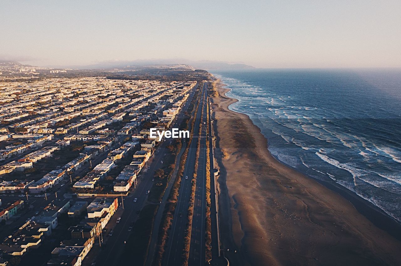 High angle view of beach by city against sky