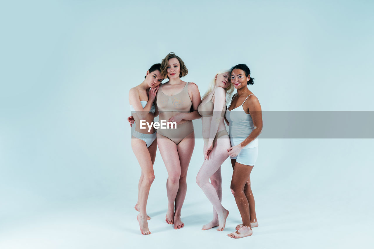 Full length of women standing against colored background
