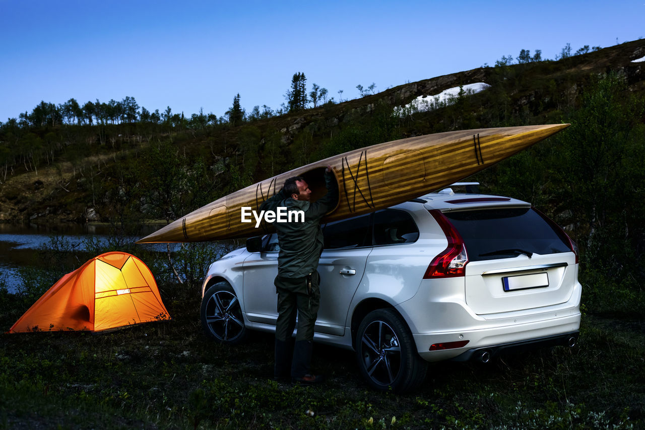 Man with kayak near tent