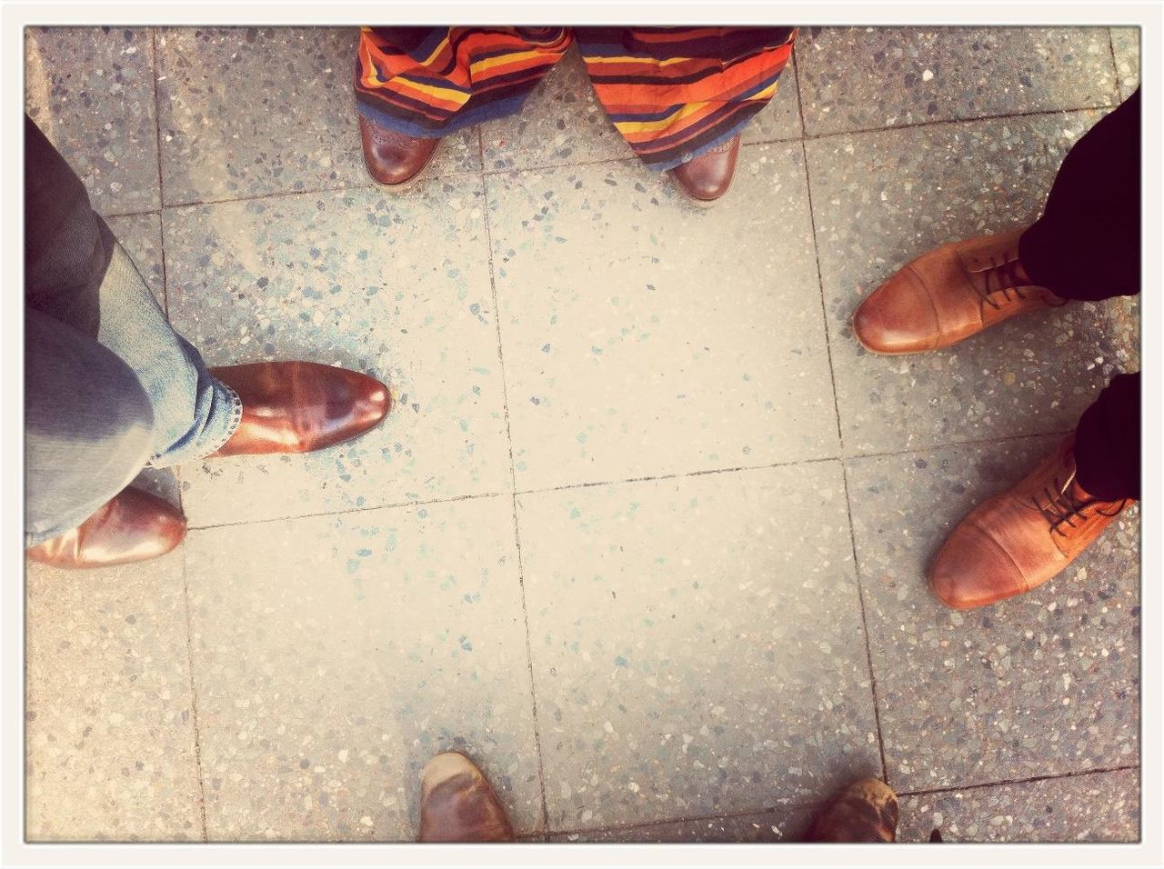 Directly above shot of men standing together on tiled floor